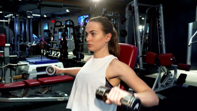 Sportliche-Mädchen-pumpt-Muskeln-der-Arme