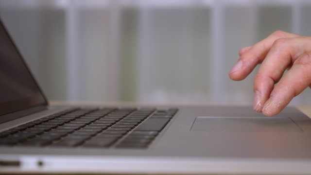 Close-up-touchpad-and-keyboard-of-laptop.-Male-fingers-gestures-at-trackpad.