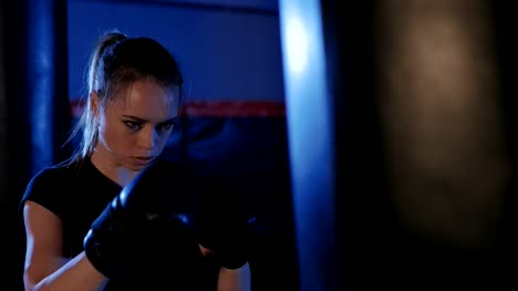 Girl-is-boxing.-Beautiful-kickboxing-woman-training-punching-bag.-Fighter-woman-fist-close-up.