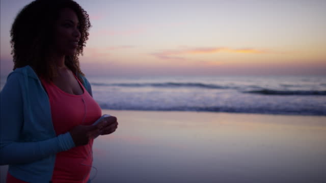Afroamericano-mujer-haciendo-ejercicio-de-caminar-en-la-playa