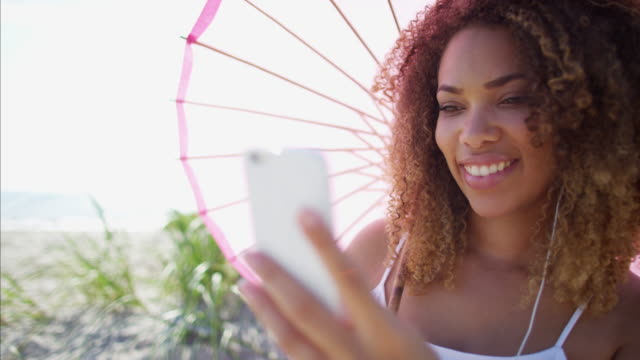 Plus-Größe-afroamerikanische-Frauen-halten-Sonnenschirm-entspannt