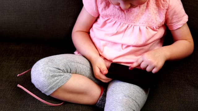 Little-girl-playing-in-the-smartphone
