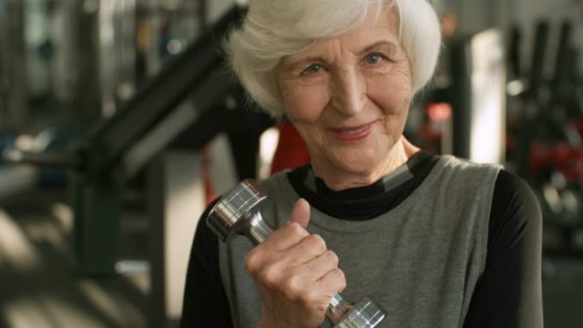 Elderly-Woman-with-Dumbbell-Smiling-for-Camera