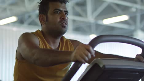 Man-Training-on-Stationary-Exercise-Bike-in-Gym