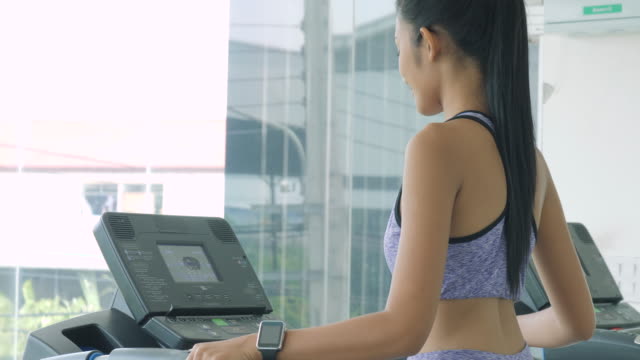 Asiatische-Mädchen-laufen-auf-dem-Laufband-im-Fitnessstudio
