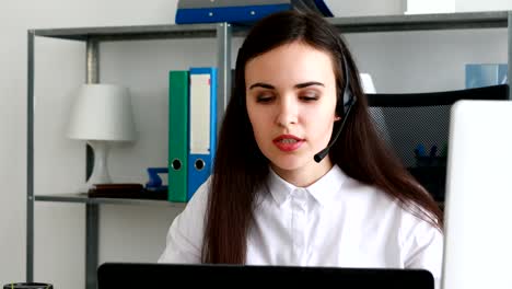 Frau-spricht-über-Kopfhörer-in-modernen-Büro