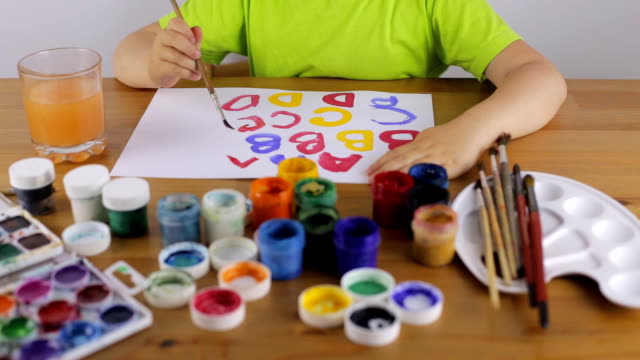 Child-learns-to-write-letters-with-paint