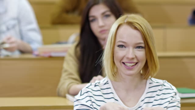 Smiling-Female-Student-Listening-to-Teacher