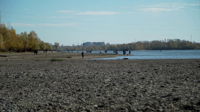 Personas-caminando-cerca-del-río-en-el-otoño