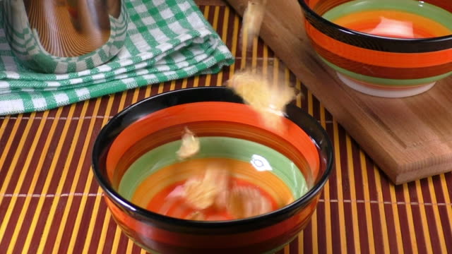 Dry-cereal-fall-into-a-multi-colored-cup-with-the-effect-of-slow-motion