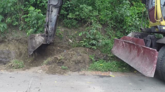 Backhoe-digging-pit-at-the-side-of-road