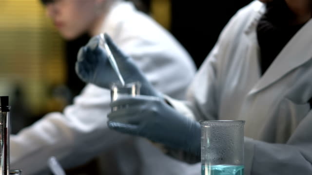 College-students-do-experiments-in-a-chemistry-lab,-close-up