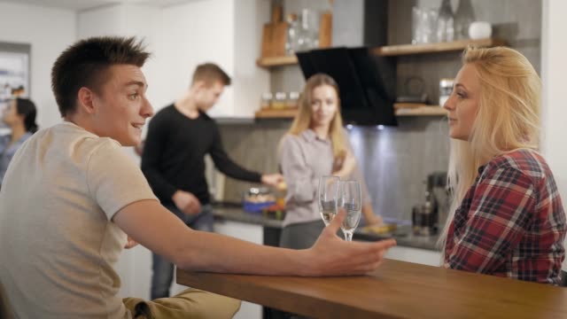 Junge-Menschen-mit-Gläsern-Champagner-sprechen-in-Küche
