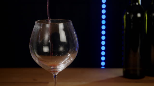 Rotwein-wird-in-ein-Glas-gegossen.