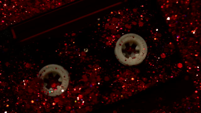 Closeup-of-video-cassette-on-red-glitter-background