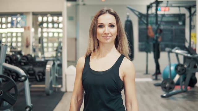 Slowmotion-shot-of-Young-fit-woman-walking-through-gym.