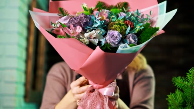 Frau-Florist-zeigt-einen-schönen-Blumenstrauß.-Hautnah.