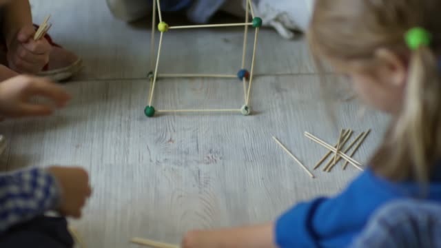 Profesor-y-los-niños-haciendo-el-cubo-de-madera