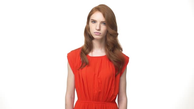 Young-beautiful-caucasian-woman-in-gorgeous-orange-dress-standing-and-say-no-isolated-over-white-background-while-looking-camera.