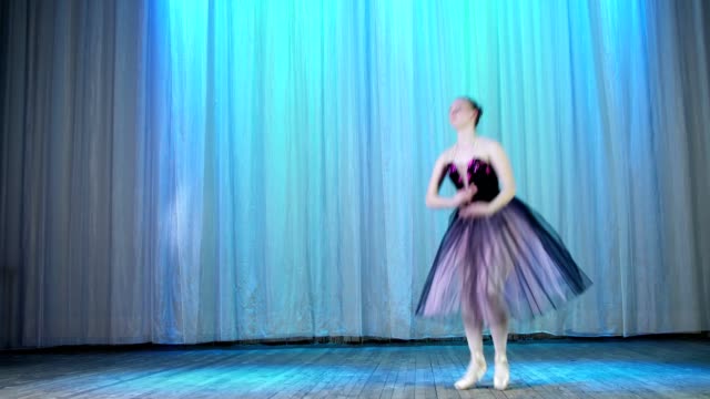 ballet-rehearsal,-on-the-stage-of-the-old-theater-hall.-Young-ballerina-in-lilac-black-elegant-dress-and-pointe-shoes,-dances-elegantly-certain-ballet-motion,-assemble-ferme