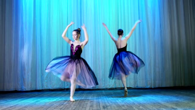 ballet-rehearsal,-on-the-stage-of-the-old-theater-hall.-Young-ballerinas-in-black-elegant-dresses-and-pointe-shoes,-dance-elegantly-certain-ballet-motion,-pirouett-from-4-position