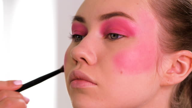 Hand-of-visagist,-eyeshadow-brush.-Young-woman,-colorful-makeup