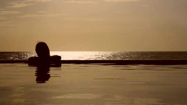 Sonnenuntergang-spiegelt-sich-in-einem-Pool-mit-Blick-aufs-Meer