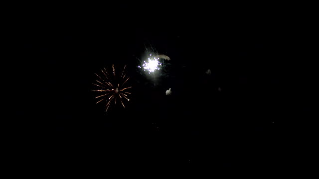 Schöne-Farben-des-Feuerwerks-am-dunklen-Nachthimmel.-Eine-helle-Kugel-purpurrote-Farbe-öffnet-sich,-und-in-dessen-Zentrum---ein-dichtes-Lichtkugel.-Vor-dem-Hintergrund-der-Feuerwerk-sehen-Sie-die-Abbildung-ein-glücklicher-Mann