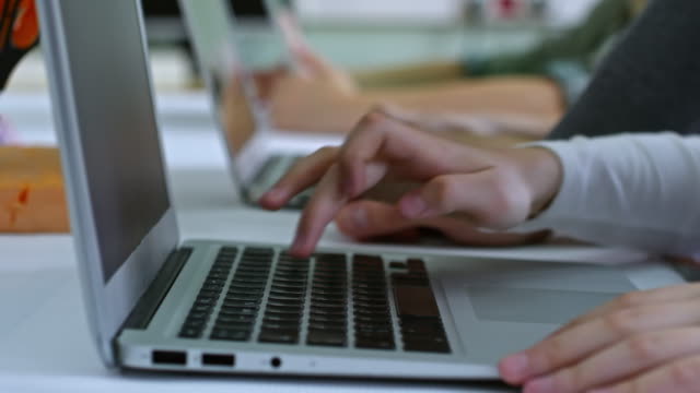 Manos-de-niño-escribiendo-en-la-computadora-portátil