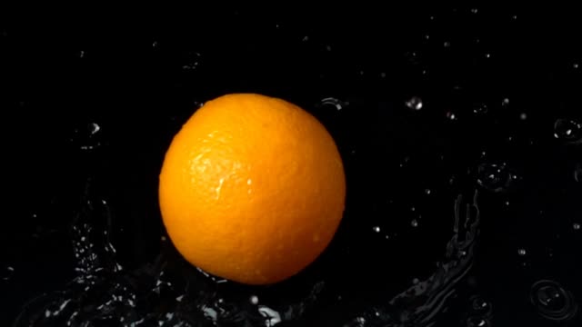 Falling-of-orange-in-water.-Slow-motion.