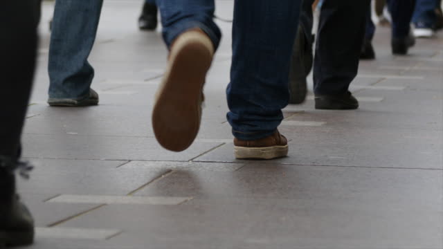 Füße-von-Menschen-zu-Fuß-auf-der-Stadtstraße