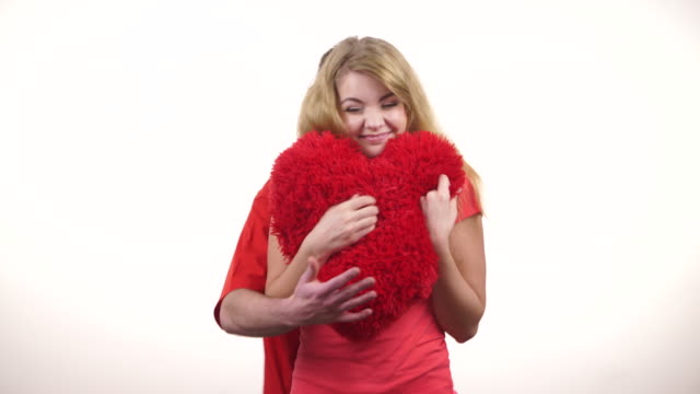 Paar-hält-rote-herzförmige-Kissen-Liebe-Symbol-4K