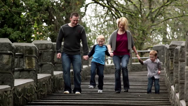 A-family-of-four-walk-down-some-steps-in-a-park