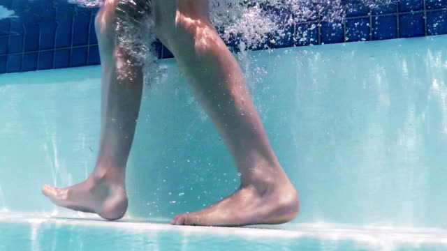 Junge-zu-Fuß-unter-Wasser-auf-Schritte-im-Schwimmbad