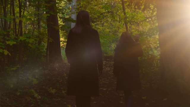 Mujer-y-su-hija-camina-en-el-bosque-de-otoño.