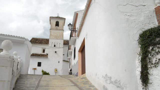 Calle-de-la-aldea-andaluza-de-Daimalos-con-una-antigua-iglesia-cristiana,-España
