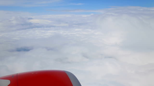 Clouds-from-the-window-of-an-airplane,-red-engine.