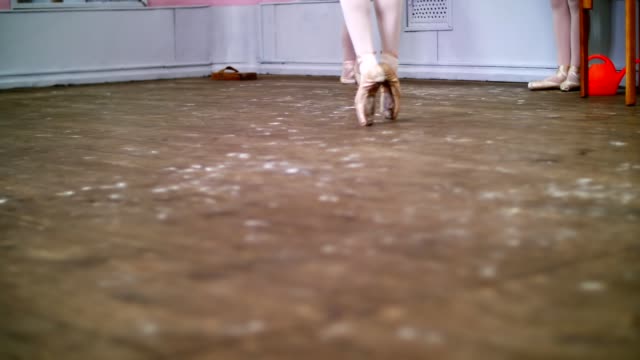 in-der-Nähe-führt,-in-Ballett-Klasse,-auf-einem-alten-Holzboden-Ballerina-Rutschpartie-En-Tournant,-sie-elegant-durch-die-ballettstunde-bewegen