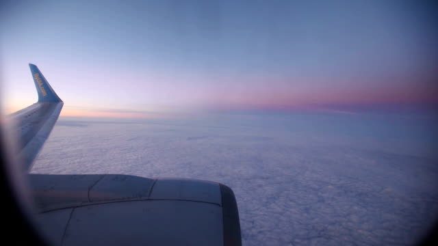 Nubes-púrpura-vistas-a-través-de-la-ventana-del-avión-a-reacción-en-la-puesta-de-sol.-HD-vídeo-alta-definición