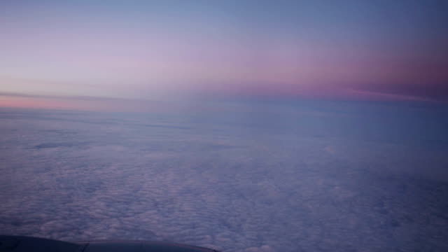 Lila-Wolken-bei-Sonnenuntergang-durch-das-Fenster-des-Jet-Flugzeug-gesehen.-HD-video-High-Definition