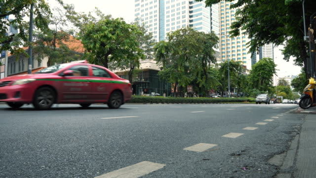 The-carriageway-in-the-city-center-with-motorbikes-and-cars,-office-buildings-in-the-background