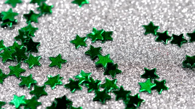 Funkelnde-Glitter-in-Form-eines-Sterns.-Close-up-auf-silbernem-Hintergrund