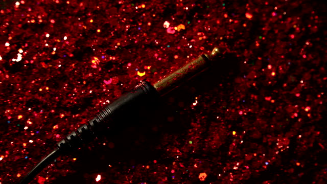 Black-cable-on-the-background-of-red-glitter