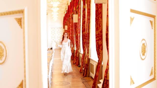 Red-haired-woman-in-vintage-ball-costume-is-walking-in-the-ball-room