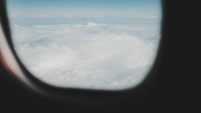 Clouds-seen-through-the-window-of-jet-airplane.-Airplane-flies-above-the-weather