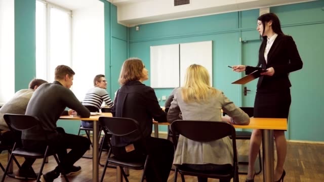 Weibliche-Lehrer-spricht-zu-Studenten-während-einer-Unterrichtsstunde-in-der-Universität