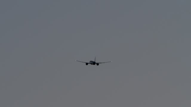 Plane-flying-in-dull-grey-sky