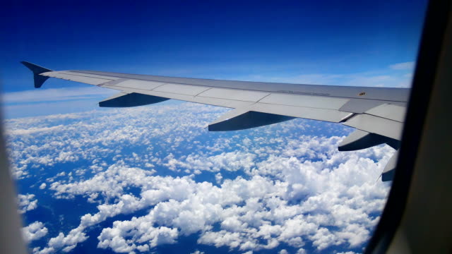 Video-Blick-aus-dem-Flugzeug-Fenster-durch-die-Flügel-und-Motor-während-des-Fluges-durch-die-Wolke-und-Bluesky-im-Transportwesen-oder-Reisen-Sie-Konzept.