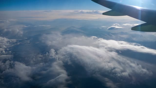 Hermosa-vista-a-través-de-la-ventana-del-avión,-avión-que-volaba-sobre-la-ciudad-en-las-montañas