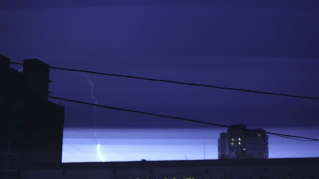 Lightning-in-the-night-sky-in-the-city,-a-bright-flash-of-light-in-the-clouds-in-the-rain,-a-thunderstorm
